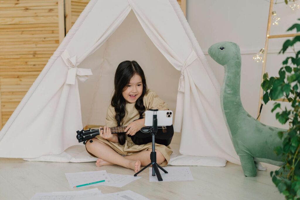 Content A Cute Girl Recording a Video while Playing Ukulele