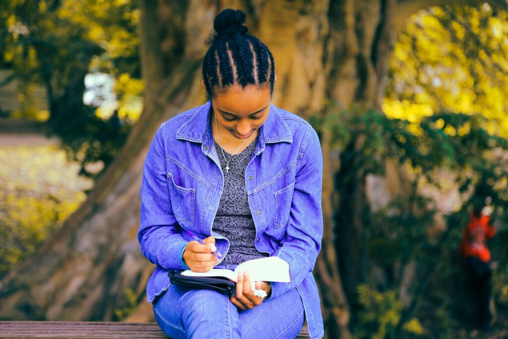 Writing tips selective focus photography of woman reading book while sitting at bench