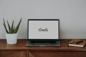 Effective Goal Setting Laptop Computer sitting on top of a wooden desk